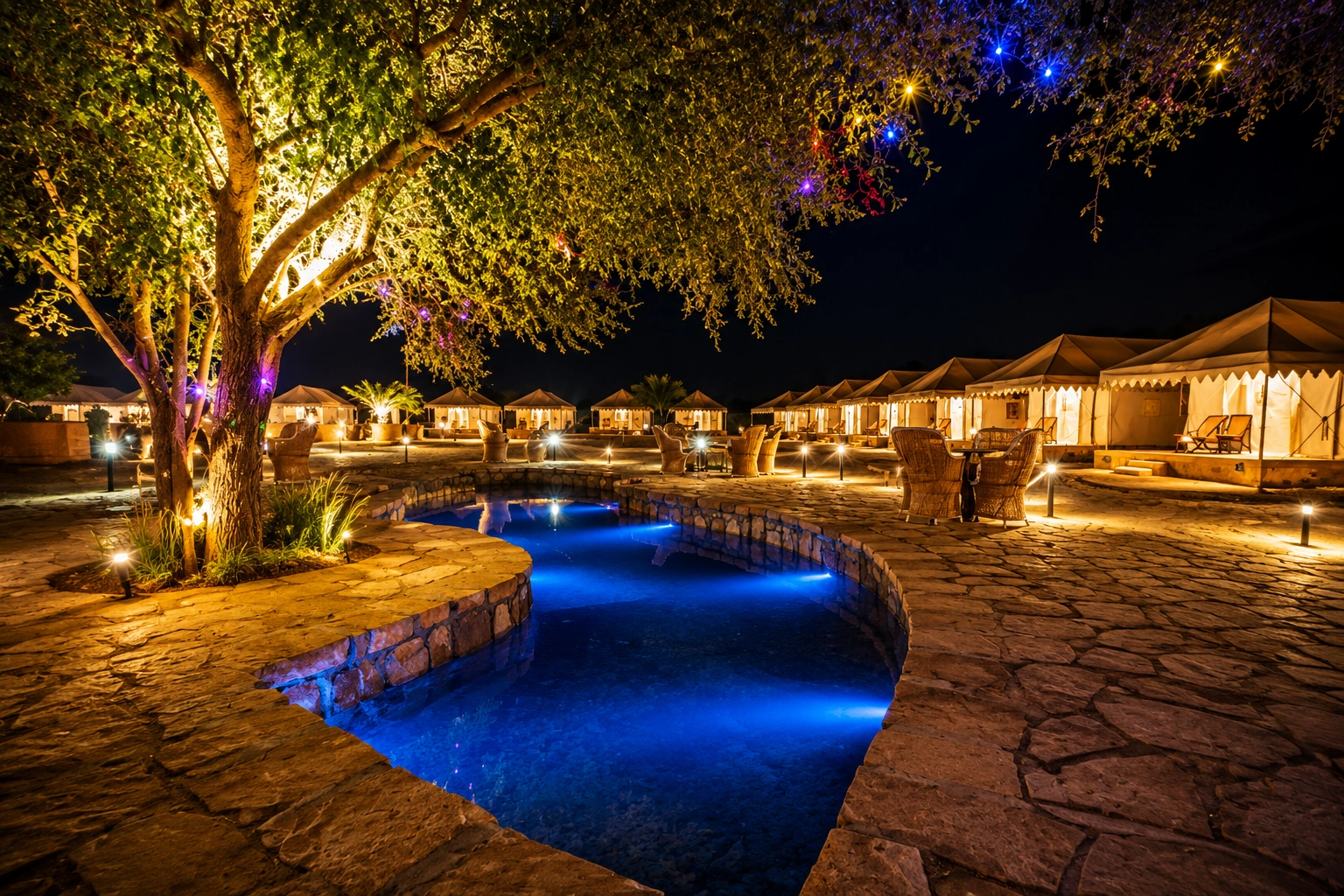 Luxury desert camp with a lit pool at night